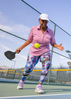 older woman playing pickleball