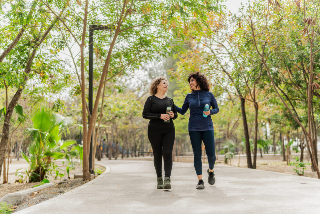 Mother and daughter talking and walking through the public park
